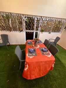 a table with a red table cloth on top of grass at Residence FATIMA in Thiès +9 photos