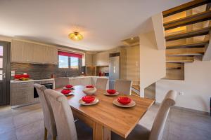 ザキントスにあるVizantida Maisonette, By TK Property Managementの木製のテーブルと椅子のあるキッチンとダイニングルーム