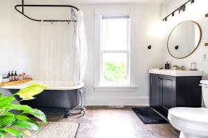 a bathroom with a black and white tub and a window at Short North Convention King Bed Free Parking! in Columbus