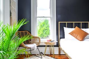 a bedroom with a bed and a chair and a plant at Short North Convention King Bed Free Parking! in Columbus +62 photos