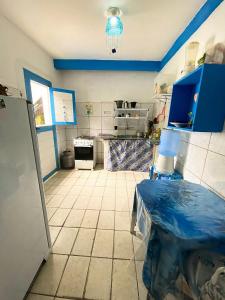 uma cozinha com armários azuis e piso em azulejo em Casinha Blue Pipa em Pipa
