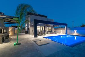 a villa with a swimming pool at night at Hollywood Exclusive Villa, by TK Property Management in Laganas