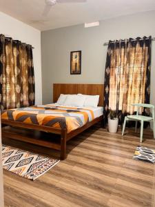 a bedroom with a bed with curtains and a chair at Malma view homestay in Kakkabe