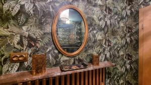 un miroir sur un mur recouvert de papier peint à motifs végétaux dans l'établissement Casa Moselle-Royal Stilvoll Urlauben an der Mosel, à Reil 29 autres photos