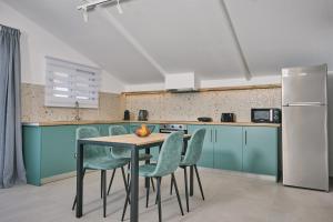 a kitchen with a table and chairs and a refrigerator at Sofita Sea View Apartment, By TK Property Management in Argasi