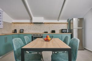 a kitchen with a table with chairs and a bowl of fruit at Sofita Sea View Apartment, By TK Property Management in Argasi +18 photos
