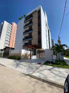 un grande edificio sul lato di una strada di Flat encantador na praia de Intermares com piscina a Ilha da Restinga