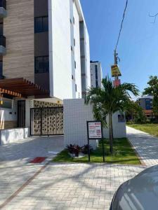 un'auto parcheggiata di fronte a un edificio con un cartello di Flat encantador na praia de Intermares com piscina a Ilha da Restinga