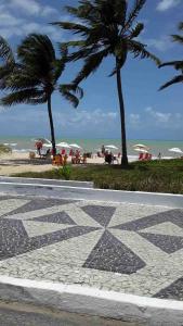 una passerella in pietra con palme e la spiaggia di Flat encantador na praia de Intermares com piscina a Ilha da Restinga