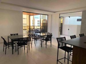 una sala da pranzo con tavoli e sedie in un edificio di Flat encantador na praia de Intermares com piscina a Ilha da Restinga