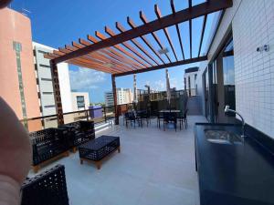 un balcone con sedie e un tavolo su un edificio di Flat encantador na praia de Intermares com piscina a Ilha da Restinga Altre 13 foto