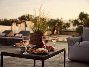 a table with two glasses of wine and a plate of food at Cozy Aura Residence, by TK Property Management in Kalpaki