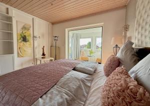 Un dormitorio con una cama grande con una ventana grande. en Westerwald Hideaway, 