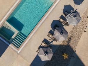 - une vue sur les chaises et les parasols à côté de la piscine dans l'établissement Samantha Villa, By TK Property Management, à Kalpaki