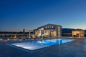 a large swimming pool in front of a house at Villa Samantha - Private Pool, 3 Ensuite Bedrooms & Complete Privacy near Laganas, By TK Premium Stays in Ambelókipoi