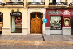 a building with a wooden door on a street at Hostal Vidamia in Málaga
