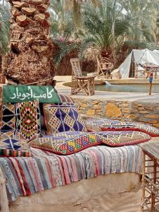 a bed with colorful pillows on top of it at Siwa ajubar resort in Siwa