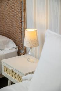 a lamp sitting on a nightstand next to a bed at Hostal Vidamia in Málaga +5 photos
