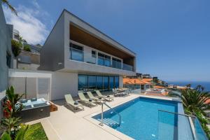 een exterieuraanzicht van een huis met een zwembad bij OurMadeira - GrandView Cristo Rei in Garajau