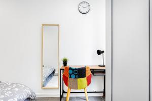 a bedroom with a desk and a chair in front of a mirror at Le Parisii I Proche RER C & METRO 7 I 2-3 peoples in Ivry-sur-Seine +16 photos