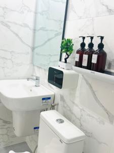 a bathroom with a toilet and a sink and a mirror at Tonjun residence kanjana  +10 photos