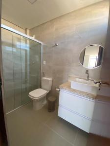a bathroom with a toilet and a sink and a mirror at Thainá · Apartamento amplo proximo a praia do Bessa. in Nossa Senhora do Livramento
