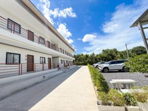 a building with cars parked in a parking lot at Tonjun residence kanjana 