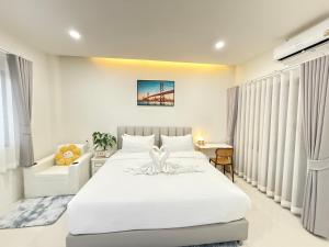 a bedroom with a white bed and a bridge at Tonjun residence kanjana 