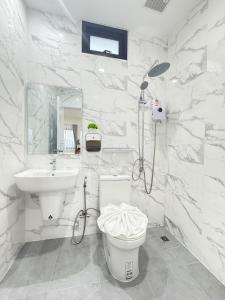 a white bathroom with a sink and a toilet at Tonjun residence kanjana 