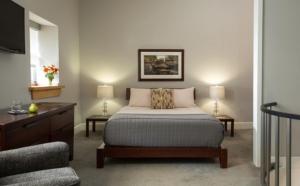a bedroom with a bed and two tables and a tv at Ledges Hotel in Hawley