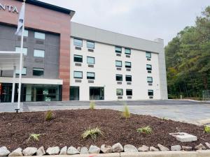 een groot wit gebouw met een vlag ervoor bij La Quinta by Wyndham Atlanta Roswell in Roswell