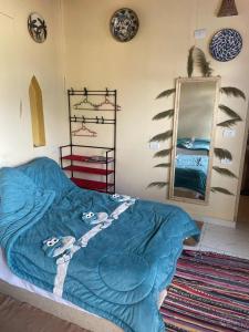 1 dormitorio con 1 cama con manta azul y espejo en Roof Tunis, en Tunis