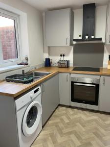 una cocina con lavadora y fregadero en Alderson House, en Hartlepool