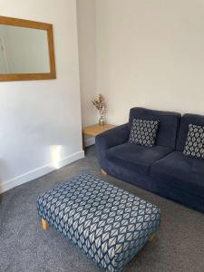 sala de estar con sofá azul y reposapiés en Alderson House, en Hartlepool