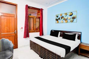 une chambre avec un lit, une fenêtre et une chaise dans l'établissement Hotel O The Swarnim, à Noida