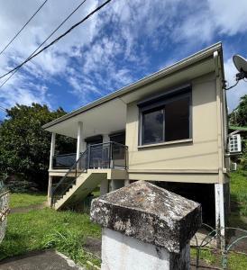 a house with a staircase in front of it at Le nid d'Emijulie - Maison familiale proche plage in Gourbeyre +18 photos