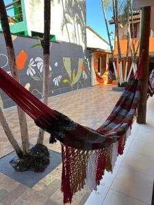 a hammock tied to two trees in a courtyard at Pousada Flor de Ipê - Arraial d'Ajuda - a 100m da Rua do Mucugê - principal Rua da cidade in Arraial d'Ajuda