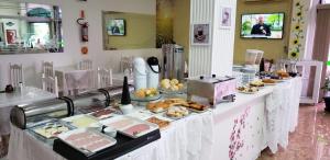 a buffet with many different types of food on a table at Hotel Vitoria in Videira