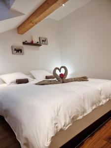 ein Schlafzimmer mit einem Bett mit zwei Stofftieren darauf in der Unterkunft Meublé 3* neuf entre lacs, montagnes et bauges. in Mûres-les Balmettes + 19 Fotos