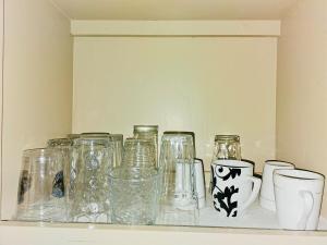 un estante con jarrones de cristal y jarrones. en Joe's Place 1 bedrm, 1 bathrm, en Sinajana