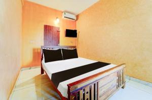 a bedroom with a bed in a room at IQ Rooms in Kozhikode