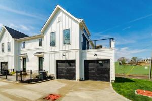 a white house with a garage at Jungle House Columbus Sleep 16 Downtown Ohio Free Parking - Near Convention Center & Nationwide Arena - 3BR Short North Luxury Home - Over 5,800 Five Star Stays in Columbus