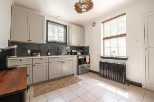 una cucina con mobili bianchi e una stufa di The Minimalist Retreat a Safe Harbor