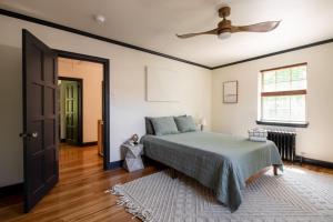 una camera da letto con un letto e un ventilatore a soffitto di The Minimalist Retreat a Safe Harbor