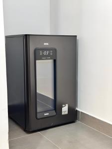 Ein schwarzer Mikrowellenherd, der an einer Wand lehnt in der Unterkunft Mar Suites Tenório in Ubatuba