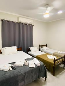 a room with two beds with towels on them at Mar Suites Tenório in Ubatuba +36 photos