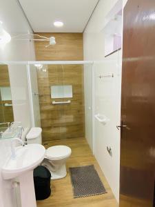 ein Badezimmer mit Toilette, Waschbecken und Dusche in der Unterkunft Mar Suites Tenório in Ubatuba