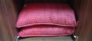 a stack of pink pillows in a closet at Homestay RAHMAJID in Segamat