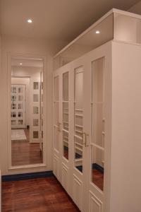 a walk in closet with white cabinets and a mirror at Parc Royale Suites Hotel in Cuenca