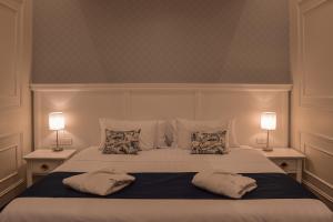 Un dormitorio con una cama con almohadas y dos lámparas. en Parc Royal Suites Hotel, en Cuenca